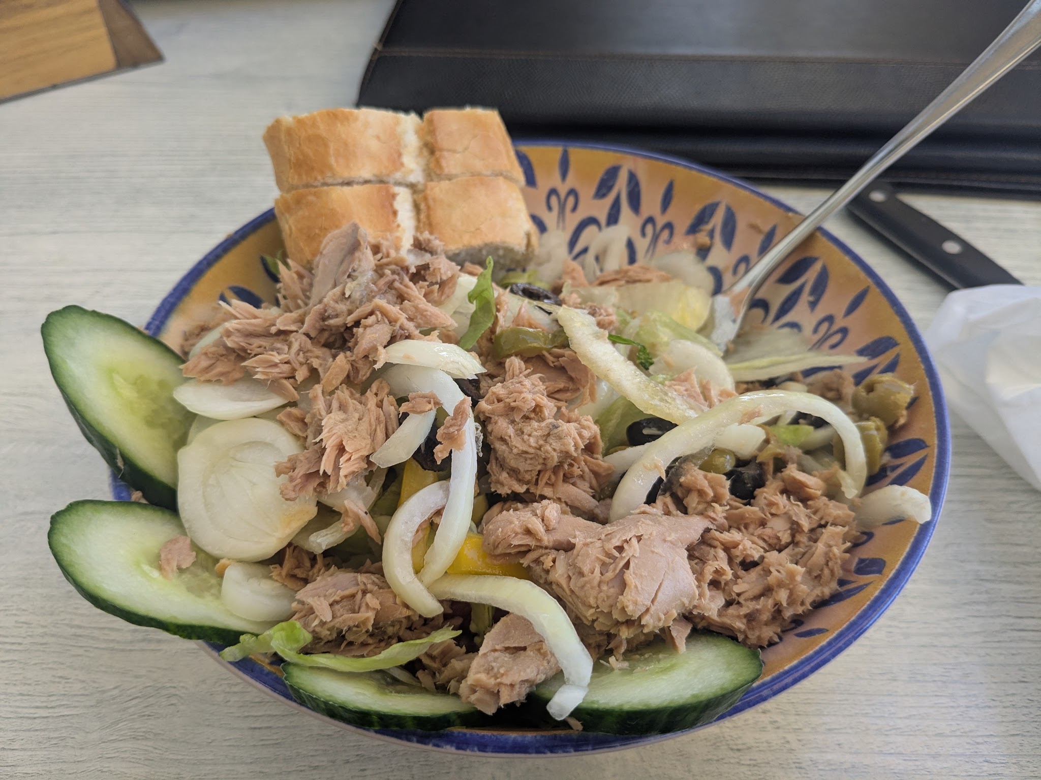 Een ruime tonijnsalade met komkommer, ui en olijven, met brood erbij