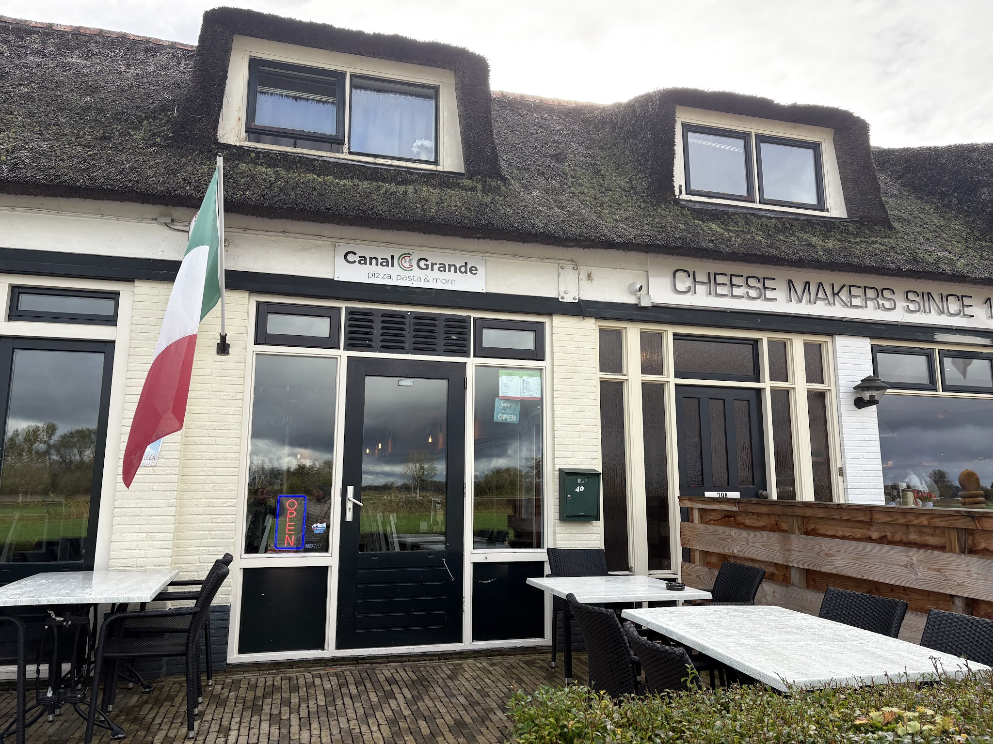 De gevel van Canal Grande met het bord pizza, pasta en more en de Italiaanse vlag